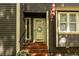 Close-up of the home's entry showing the front door, brick steps, and well-maintained landscaping at 6035 Sentinel Dr, Raleigh, NC 27609
