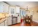 Cozy eat-in kitchen with white cabinets, granite countertops, stainless steel dishwasher, wood floors, and a chandelier above table at 6035 Sentinel Dr, Raleigh, NC 27609