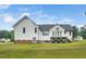 Rear exterior showcasing a well-maintained lawn and elevated deck, perfect for outdoor enjoyment at 6737 Vernie Dr, Raleigh, NC 27603