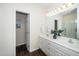 Bathroom featuring dual sinks, a large mirror and an open doorway at 6737 Vernie Dr, Raleigh, NC 27603