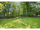 Large backyard featuring green grass and mature trees at 6912 Baywood Dr, Raleigh, NC 27613