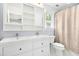 Bathroom with double sinks, bright white cabinetry, framed mirror, and shower with a curtain at 6912 Baywood Dr, Raleigh, NC 27613