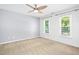 Neutral bedroom featuring a ceiling fan, carpeted floors and natural light at 6912 Baywood Dr, Raleigh, NC 27613