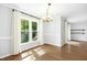 Bright dining room featuring wood floors, a modern chandelier, and a large window with view to the wooded exterior at 6912 Baywood Dr, Raleigh, NC 27613