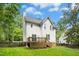 Exterior view of the home with a wood deck, stairs, and green grass at 6912 Baywood Dr, Raleigh, NC 27613