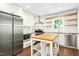 Bright kitchen featuring stainless steel appliances, white subway tile, floating wood shelves and kitchen island with seating at 6912 Baywood Dr, Raleigh, NC 27613