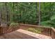 Wooden back deck with wooden railing overlooking a private wooded backyard with mature trees at 7 Hitching Rack Ct, Durham, NC 27713