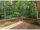Back deck overlooking a private, wooded backyard with mature trees and string lights overhead at 7 Hitching Rack Ct, Durham, NC 27713