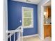 Upstairs hallway with a blue accent wall and a view into the renovated bathroom with granite countertop at 7 Hitching Rack Ct, Durham, NC 27713