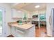 Bright kitchen featuring white cabinets, granite countertops, and stainless steel appliances at 7 Hitching Rack Ct, Durham, NC 27713