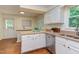 Well-lit kitchen boasts granite counters, white cabinets, and stainless steel dishwasher at 7 Hitching Rack Ct, Durham, NC 27713