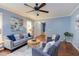 Well-lit living room with hardwood floors, a ceiling fan, and comfortable seating at 7 Hitching Rack Ct, Durham, NC 27713