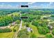 Aerial view showcases a home nestled amidst lush greenery, with a nearby pond, close to Angier, NC at 750 Greenleaf Rd, Angier, NC 27501
