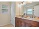 Bathroom featuring dual sink vanity with granite countertop, ample storage, and natural light at 750 Raymond Dr, Clayton, NC 27527