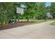 Long driveway with basketball hoop leads to a charming home surrounded by mature trees and manicured landscaping at 750 Raymond Dr, Clayton, NC 27527
