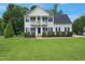 Charming two-story home with a beautifully maintained lawn, American flag, and welcoming front porch at 750 Raymond Dr, Clayton, NC 27527