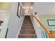 Carpeted staircase with handrail and decorative artwork on the walls at 750 Raymond Dr, Clayton, NC 27527