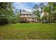 Backyard with a lush lawn, trees, deck and rear exterior view of the home at 7520 Milestone Ct, Raleigh, NC 27615