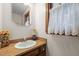 Traditional bathroom features a wood vanity, sink, and window with natural light at 7520 Milestone Ct, Raleigh, NC 27615
