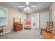A quaint bedroom featuring a ceiling fan, plush carpet and a view to the ensuite bath at 7520 Milestone Ct, Raleigh, NC 27615