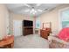 A cozy bedroom with neutral walls, ceiling fan, carpet and matching wood furnishings at 7520 Milestone Ct, Raleigh, NC 27615