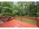 Outdoor deck with wood flooring and railings surrounded by lush green trees at 7520 Milestone Ct, Raleigh, NC 27615