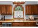 Cozy kitchen sink features a window view, wood cabinets, and modern appliances at 7520 Milestone Ct, Raleigh, NC 27615