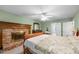 Comfortable main bedroom featuring a brick fireplace, carpeted floors, and bright lighting at 7520 Milestone Ct, Raleigh, NC 27615