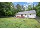 Home exterior showing a fenced-in backyard and deck surrounded by large trees, offering outdoor privacy at 7603 Nichols Dr, Rougemont, NC 27572