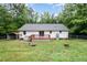Home exterior featuring a wood deck, white siding, and spacious backyard with chain-link fence at 7603 Nichols Dr, Rougemont, NC 27572