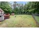 View from the side of the home featuring a spacious, fenced-in backyard and storage shed at 7603 Nichols Dr, Rougemont, NC 27572