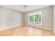 Bright bedroom featuring a ceiling fan, hardwood floors, and a large window providing natural light at 7603 Nichols Dr, Rougemont, NC 27572