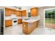 Well-lit kitchen featuring wood cabinets, white appliances, a breakfast bar and access to a deck at 7603 Nichols Dr, Rougemont, NC 27572