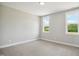 Carpeted bedroom featuring two large windows providing natural light and outdoor views at 7719 Barefoot Rd, Fuquay Varina, NC 27526