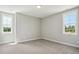 Cozy bedroom with neutral carpet and two windows providing natural light at 7719 Barefoot Rd, Fuquay Varina, NC 27526