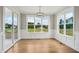 Bright dining room with hardwood floors, modern lighting, and large windows showcasing lush greenery at 7719 Barefoot Rd, Fuquay Varina, NC 27526