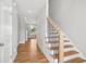 Light-filled entryway with wooden floors, staircase with metal spindles, and an adjacent view to the yard at 7719 Barefoot Rd, Fuquay Varina, NC 27526