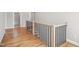 Upstairs hallway with hardwood flooring, wood and black iron handrail, and views into other rooms at 7719 Barefoot Rd, Fuquay Varina, NC 27526