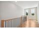 Light filled hallway with wood floors, a wooden handrail, and large windows facing outwards at 7719 Barefoot Rd, Fuquay Varina, NC 27526