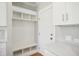 Bright mudroom features white shelving, cabinets, a bench, and a door to the outside at 7719 Barefoot Rd, Fuquay Varina, NC 27526