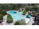 Aerial shot of a community pool with a slide and splash pad surrounded by lush greenery and comfortable lounge chairs at 78 Salt Cedar Ln, Chapel Hill, NC 27516