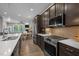 Modern kitchen with stainless steel appliances, dark cabinets, and sleek countertops open to living area at 78 Salt Cedar Ln, Chapel Hill, NC 27516