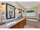 Well-lit bathroom with double sinks, granite countertops, and a luxurious bathtub at 101 Collinson Dr, Chapel Hill, NC 27514
