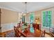 Formal dining area features elegant lighting, a polished wood table, and views of the surrounding greenery at 101 Collinson Dr, Chapel Hill, NC 27514