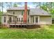 Rear exterior showcasing a spacious two-story home with a deck, brick chimney, and well-maintained lawn at 106 Ridgepath Way, Cary, NC 27511