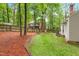 Beautifully landscaped backyard with tiered garden beds, green grass, mature trees, and a well-maintained fence at 106 Ridgepath Way, Cary, NC 27511