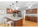 Well-lit kitchen boasts stainless appliances, granite counters and a center island with bar stool seating at 106 Ridgepath Way, Cary, NC 27511