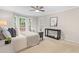 Serene main bedroom featuring a ceiling fan, neutral carpet, and a view of the yard from the bay windows at 106 Ridgepath Way, Cary, NC 27511