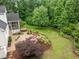 Aerial view of backyard with patio, outdoor kitchen, screened-in porch, hot tub, and lush landscaping at 109 Henrys Ridge Rd, Pittsboro, NC 27312