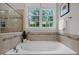 Tranquil bathroom with a large soaking tub, a view to the outdoors, and tile surround at 109 Henrys Ridge Rd, Pittsboro, NC 27312